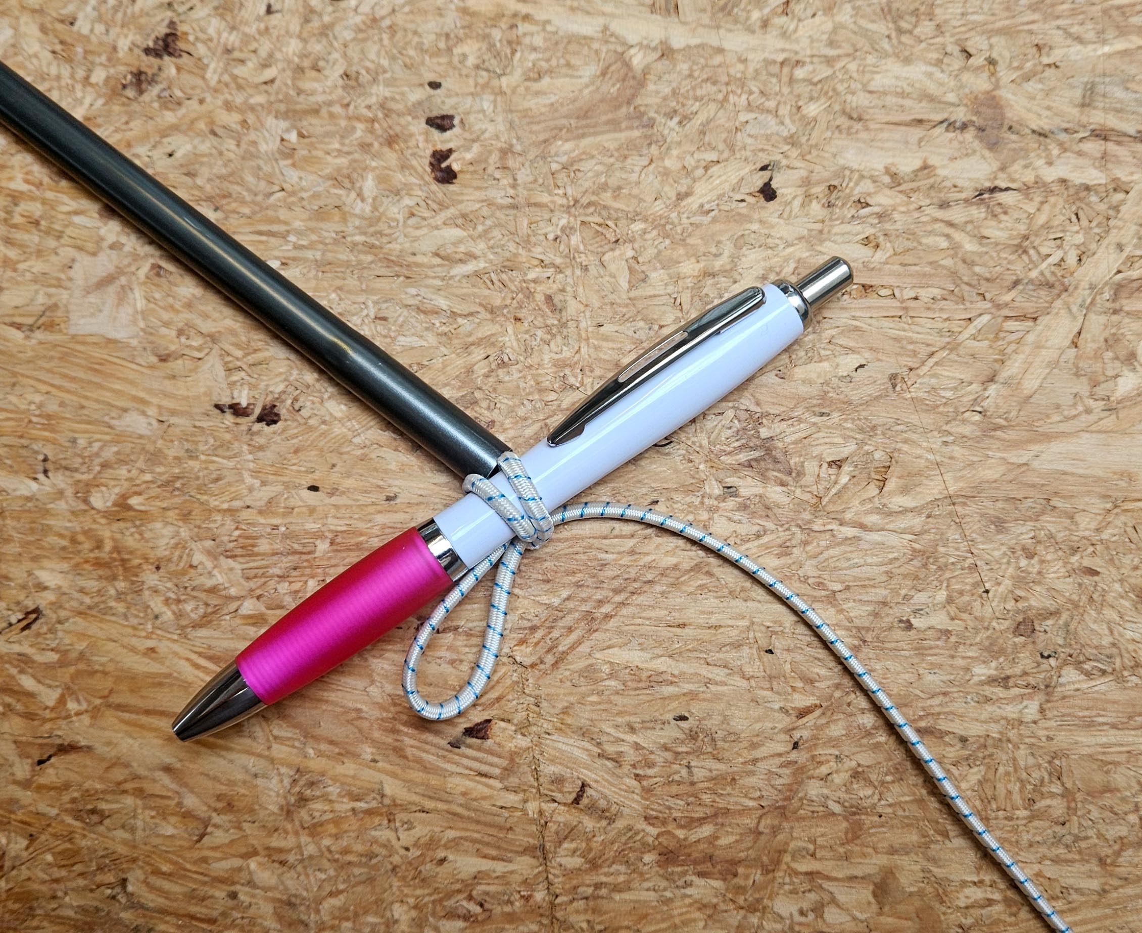 Gummiseil beim Einfädeln beispielhaft mit einem Stift fixiert, um es am Zurückrutschen zu hindern